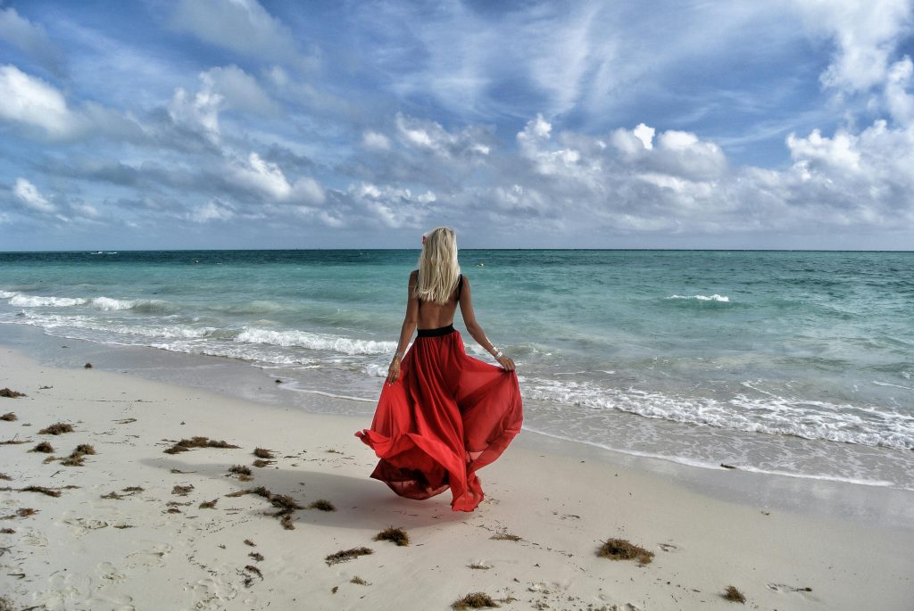 pexels-photo-707377-707377 A woman in a flowing red dress enjoys a walk on a scenic Bahamas beach.